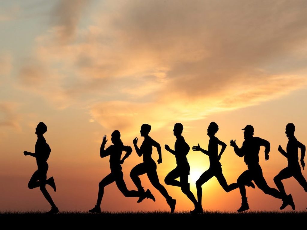 A group of people running, with one person in the lead